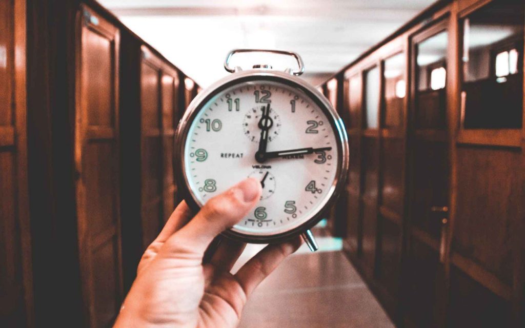 person holding an alarm clock