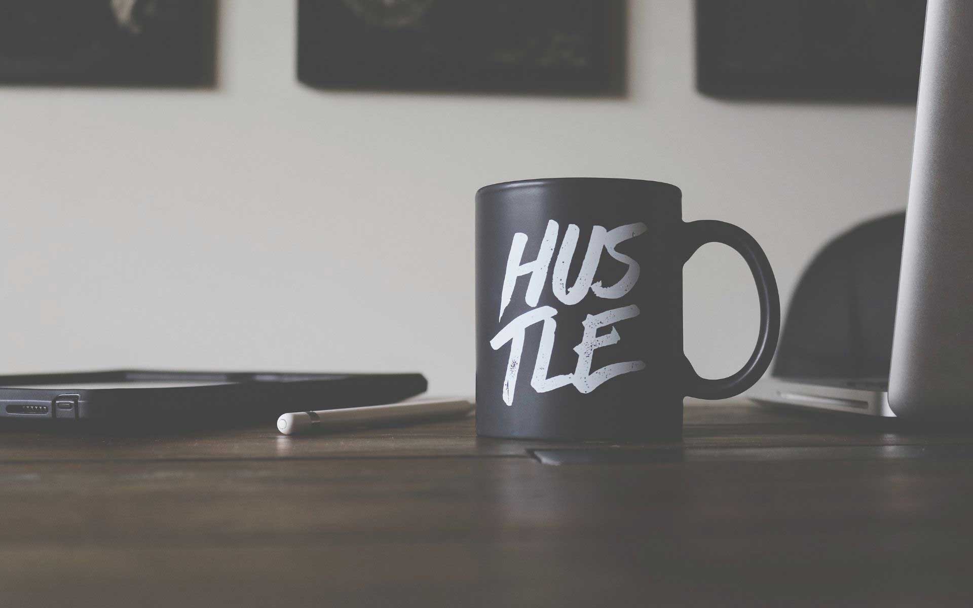 business-insurance mug with hustle written on it