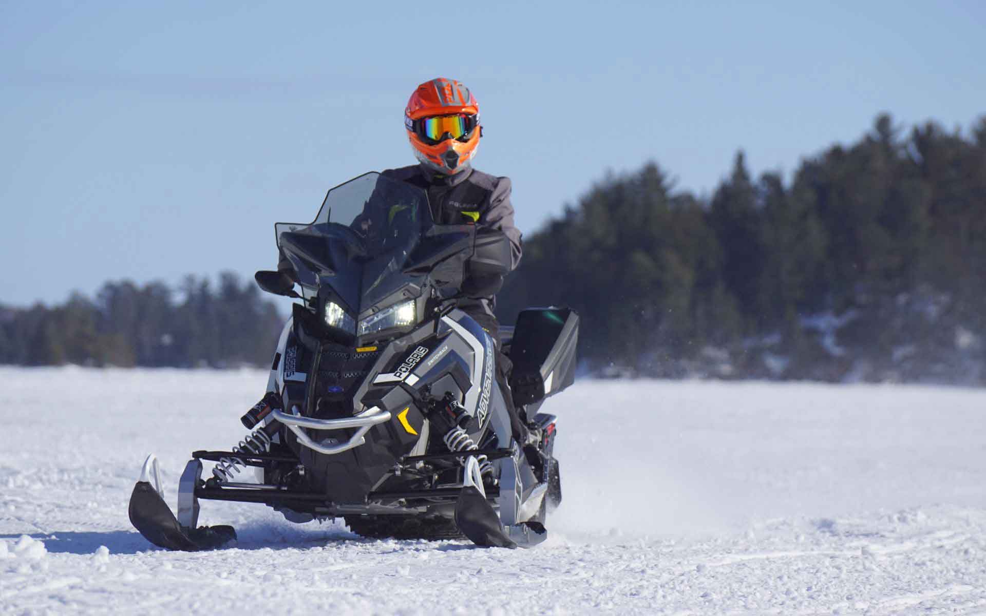 specialty-insurance person riding a snowmobile on a snowy lake